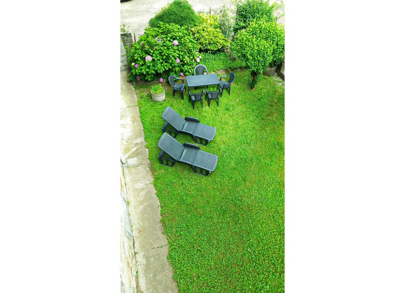 Ca. 80 m² großer Gemeinschaftsgarten mit Sitzgelegenheit und Liegestühlen