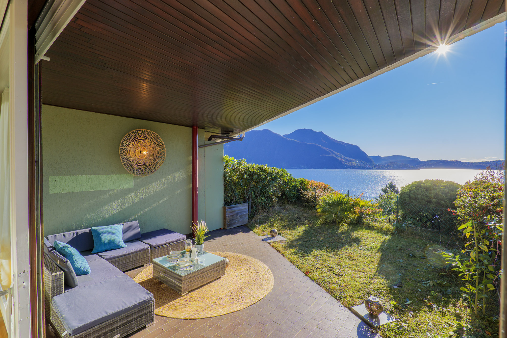 Großzügiger Außenbereich bestehend aus einer ca. 15 m² großen überdachten Terrasse und einen angrenzenden ca. 20 m² großen Sonnengarten mit jeweils atemberaubender Sicht auf den See und die gegenüber liegenden Berge