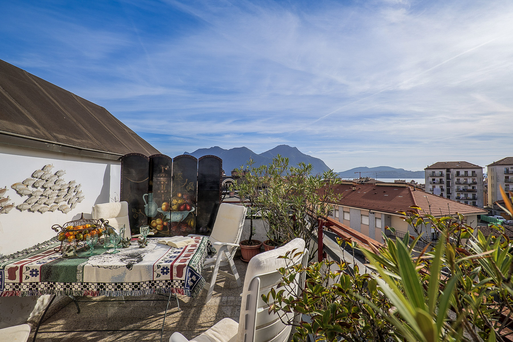 Ca. 10 m² großer Sonnenbalkon mit Blick auf die Dächer von Intra, den See und die gegenüberliegenden Berge